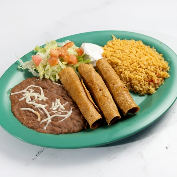 De Pasada's Mexican dish with three taquitos, refried beans, rice, lettuce, tomatoes, and sour cream.