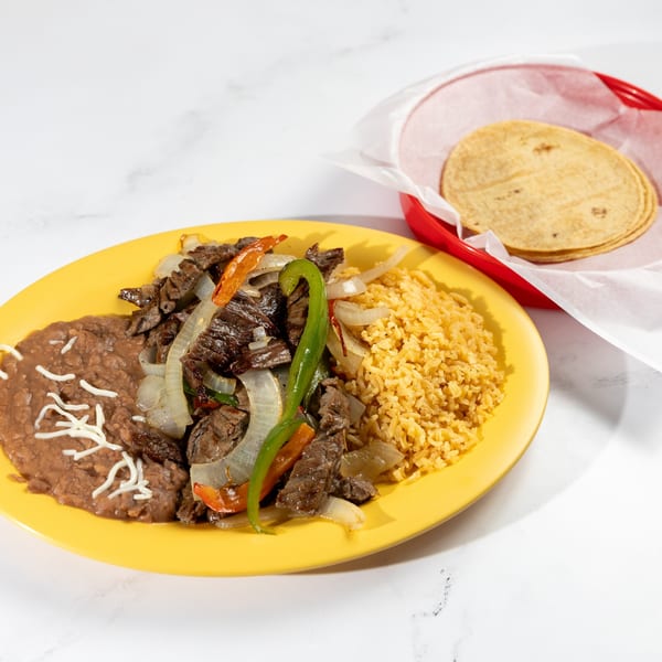 De Pasada's carne asada with rice, refried beans, and a side of tortillas.