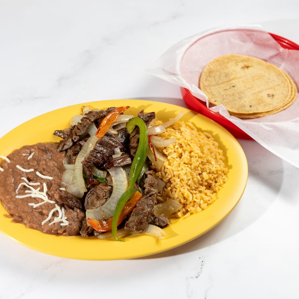De Pasada's carne asada with rice, refried beans, and a side of tortillas.